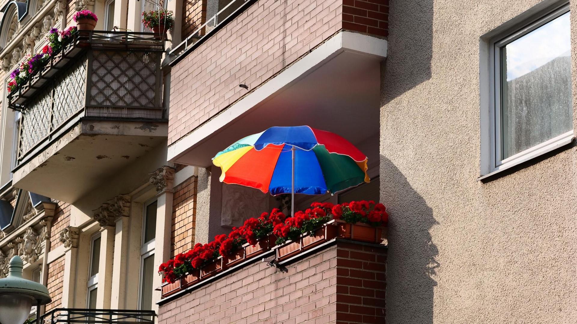 Ein bunter Sonnenschirm steht auf dem Balkon eines Mietshauses aus den 1920er/1930er im Stadtteil Steglitz in Berlin am 12.06.2020. Foto: Wolfram Steinberg/dpa | Verwendung weltweit Ein bunter Sonnenschirm steht auf dem Balkon eines Mietshauses aus den 1920er/1930er im Stadtteil Steglitz in Berlin am 12.06.2020. Foto: Wolfram Steinberg/dpa | Verwendung weltweit