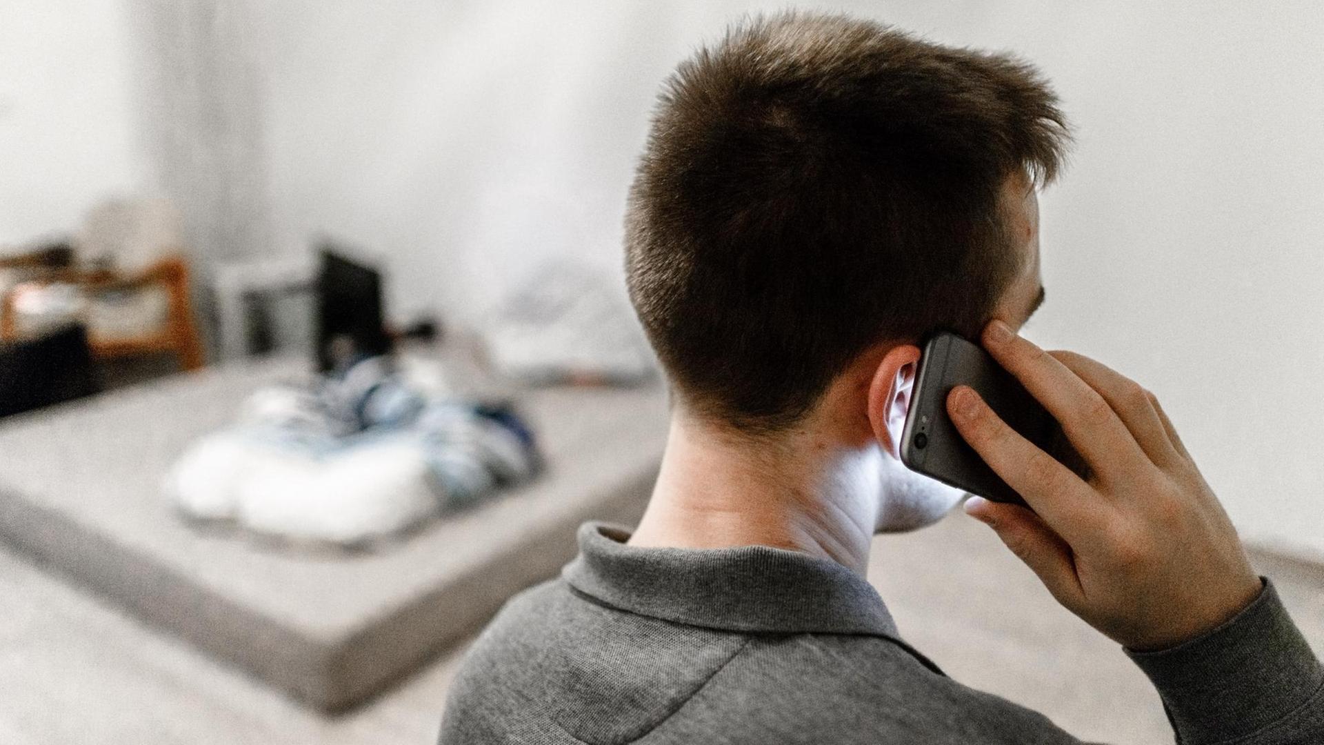 Ein Mann ruft mit seinem Handy jemanden an. Ein Mann ruft mit seinem Handy jemanden an.