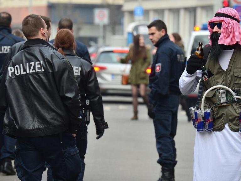 Ein als Terrorist verkleideter Karnevalist mit einem Gürtel aus Energydrinks, der an einen Sprengstoffgürtel erinnert