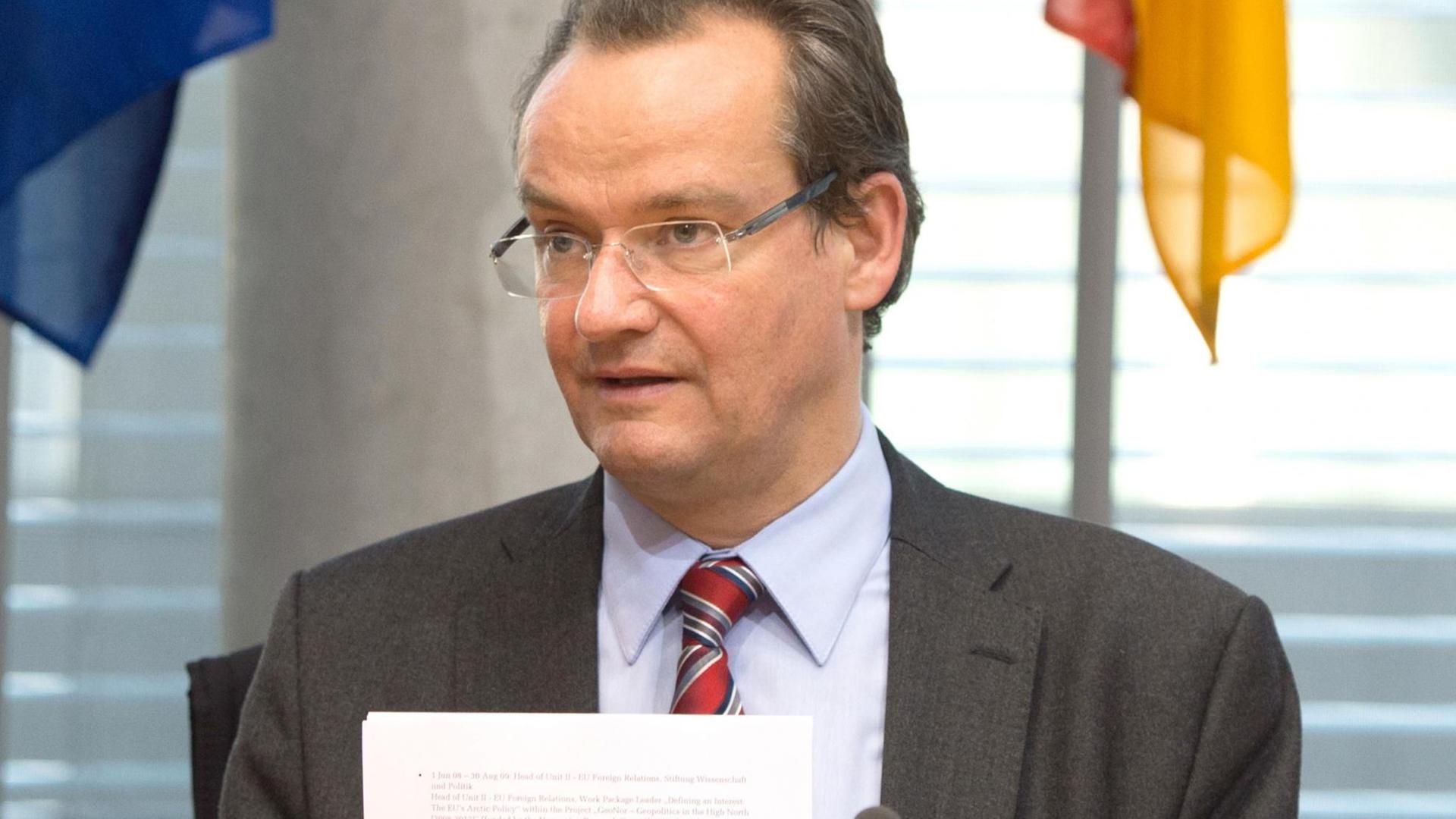 Gunther Krichbaum (CDU) hält Papiere in den Händen.