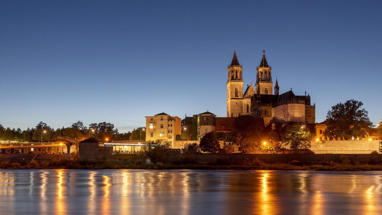 In der Elbe spiegeln sich die Lichter der Straßenlaternen, dahinter ist der Magdeburger Dom zu sehen. In der Elbe spiegeln sich die Lichter der Straßenlaternen, dahinter ist der Magdeburger Dom zu sehen.