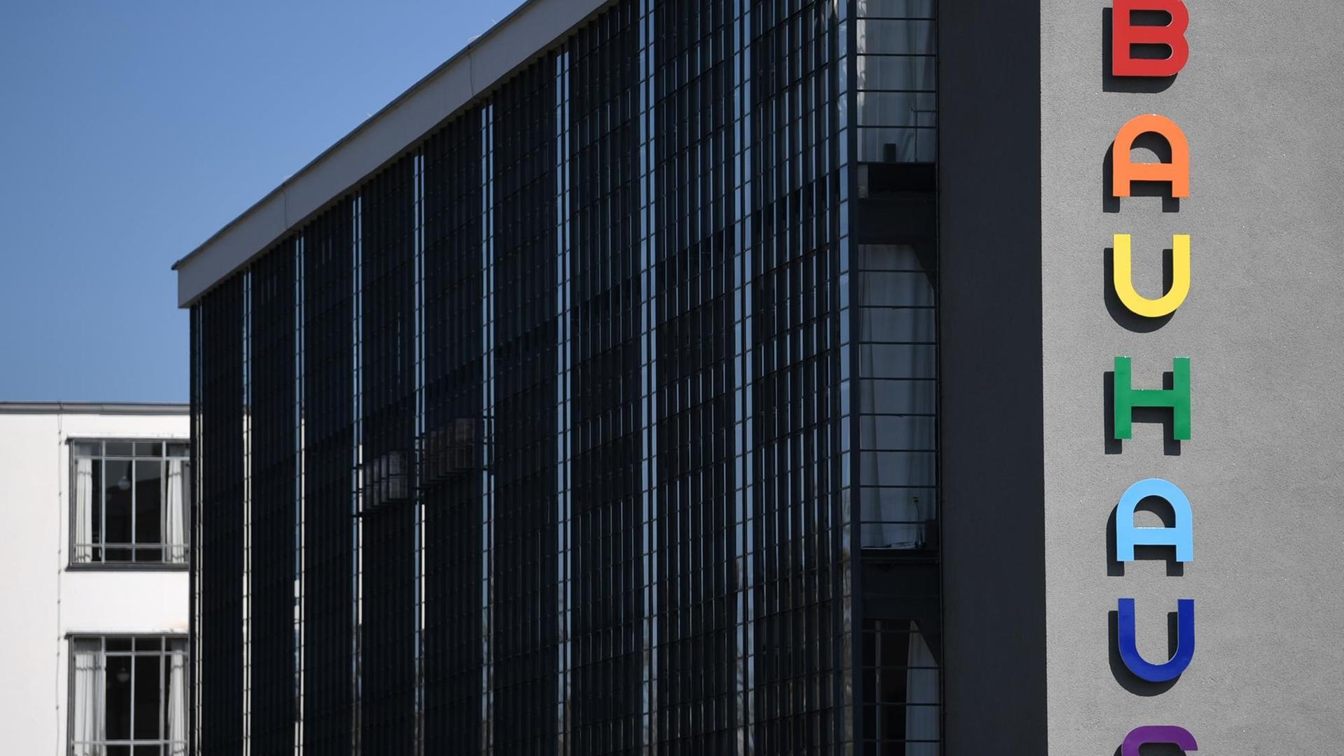 Der markante Bauhaus-Schriftzug an der Fassade des Bauhausgebäudes in Dessau-Roßlau leuchtet in bunten Farben. Der markante Bauhaus-Schriftzug an der Fassade des Bauhausgebäudes in Dessau-Roßlau leuchtet in bunten Farben.