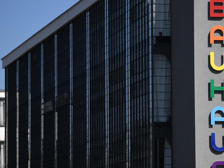Der markante Bauhaus-Schriftzug an der Fassade des Bauhausgebäudes in Dessau-Roßlau leuchtet in bunten Farben.
