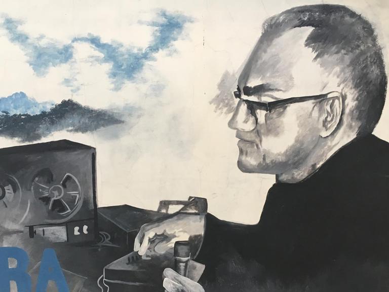 Ein Graffiti zeigt Oscar Romeros vor einem Radio.