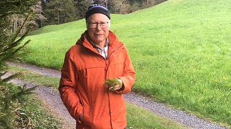 Ein älterer Herr steht auf einem Waldweg. Ein älterer Herr steht auf einem Waldweg.