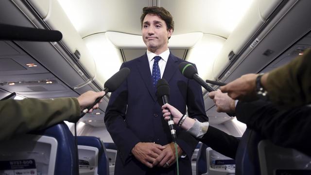Mehrere Hände halten Justin Trudeau Mikrofone entgegen. Er gibt eine Erklärung zu einem Foto aus dem Jahr 2001 ab, das ihn mit einem dunkel geschminkten Gesicht, einem Gewand und einem Turban zeigt.