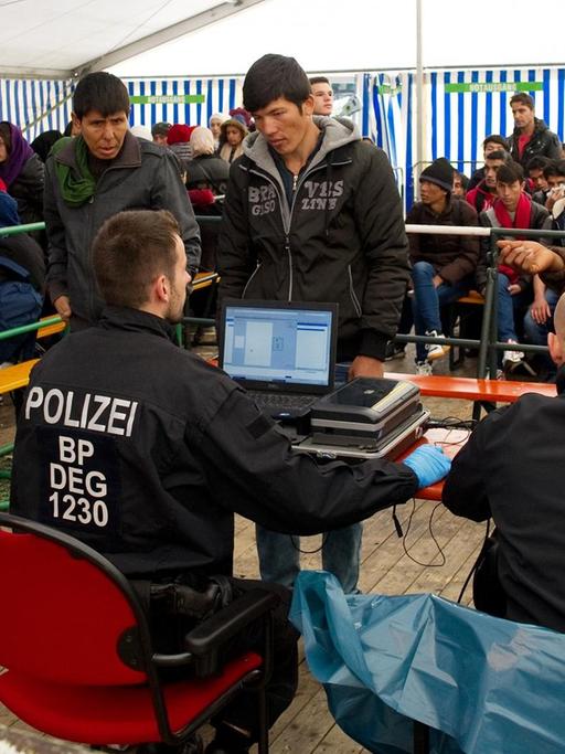 Flüchtlinge warten am 2. November 2015 in Passau (Bayern) am Bahnhof in einem Versorgungszelt auf ihre Registrierung.