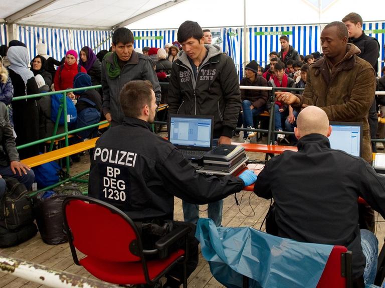 Flüchtlinge warten am 2. November 2015 in Passau (Bayern) am Bahnhof in einem Versorgungszelt auf ihre Registrierung.