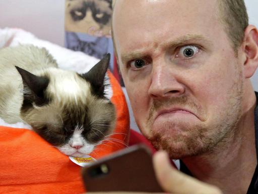 Ein Fan macht ein Foto von sich und Grumpy Cat, aufgenommen 2014 bei Bleecker Street Records in New York