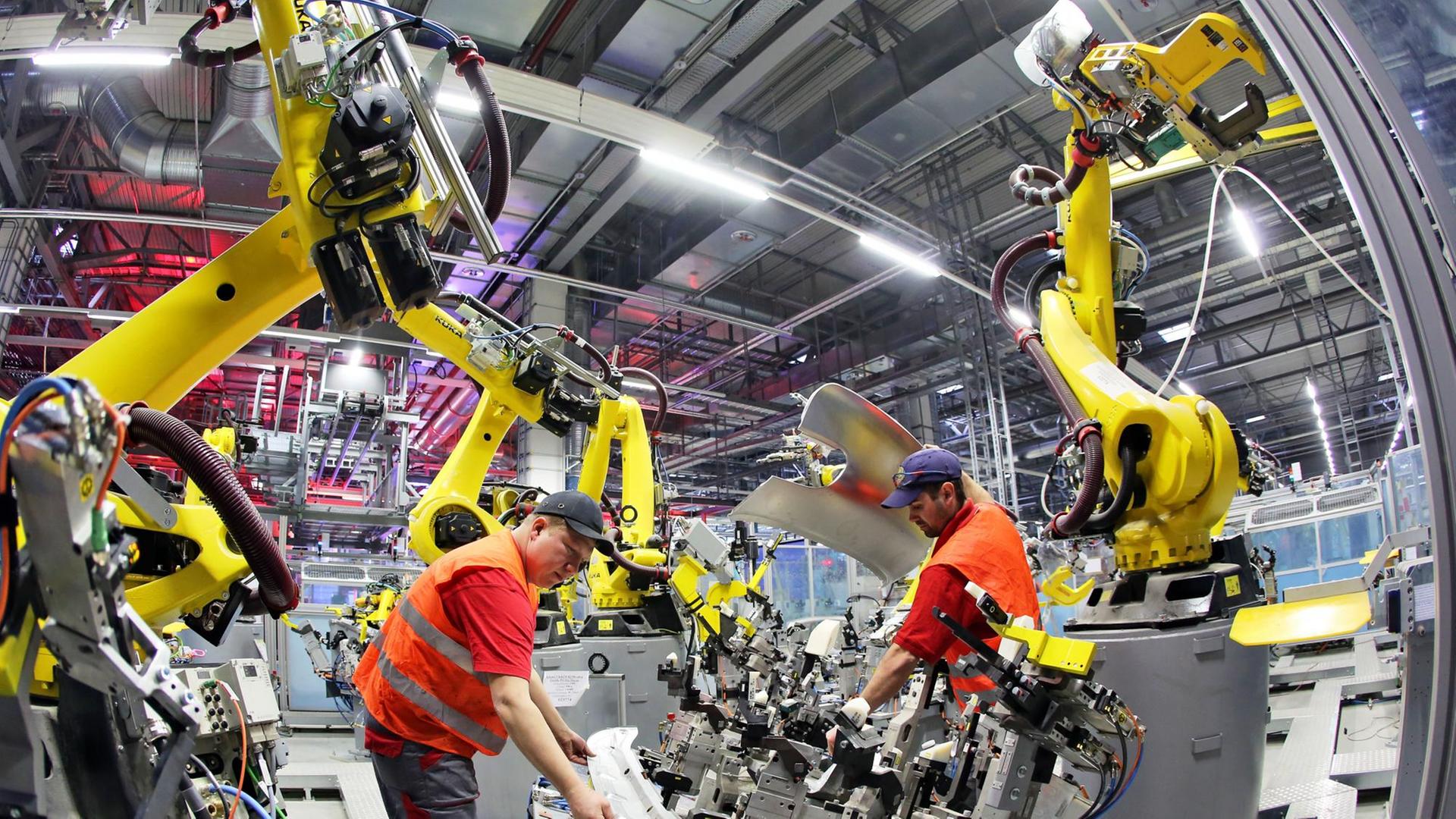 Mechatroniker installieren einen Roboter in der Karosseriefertigung des Sportwagenbauers Porsche.