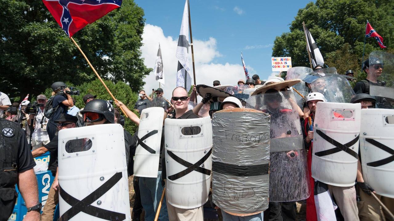 Mit Schulzschilden und Stöcken ausgerüstete rechte Demonstranten in der US-Stadt Charlottesville.
Mit Schulzschilden und Stöcken ausgerüstete rechte Demonstranten in der US-Stadt Charlottesville.