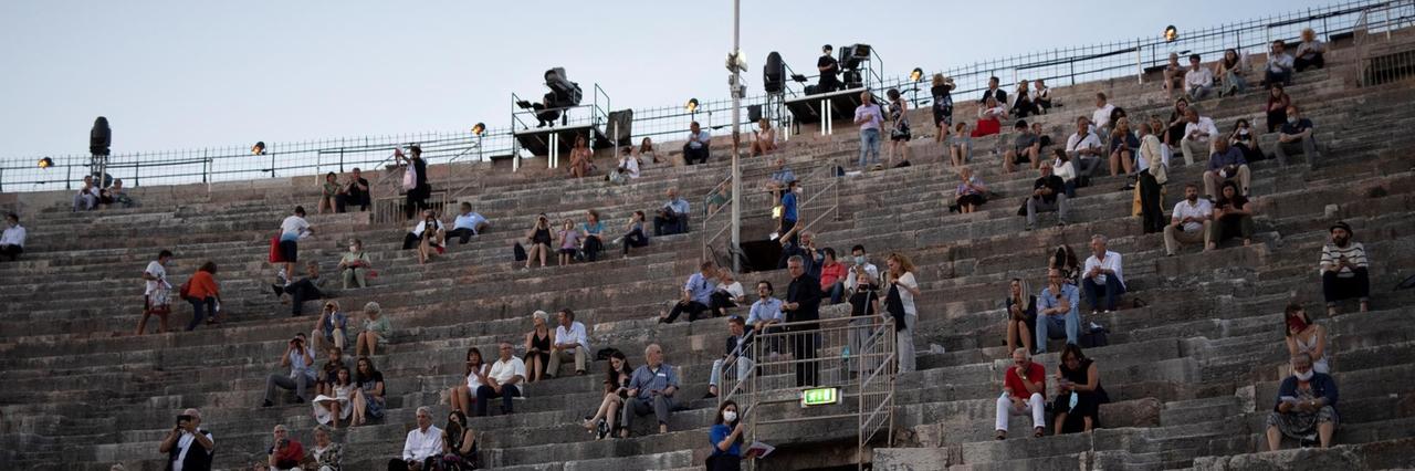 Zuschauerinnen und Zuschauer sitzen mit coronabedingtem Abstand auf den Steinstufen der Arena Zuschauerinnen und Zuschauer sitzen mit coronabedingtem Abstand auf den Steinstufen der Arena
