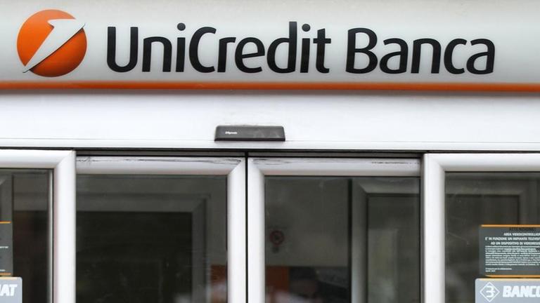 Zwei Frauen mit Regenschirmen stehen vor einer Filiale der Unicredit-Bank in Rom Zwei Frauen mit Regenschirmen stehen vor einer Filiale der Unicredit-Bank in Rom