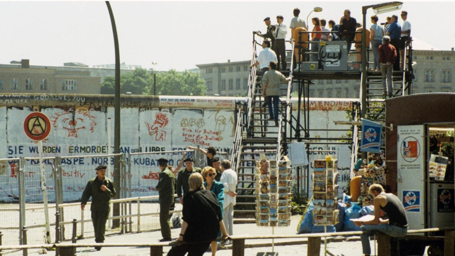 Aussichtsplattform mit Besuchern am Potsdamer Platz in West-Berlin. Links stehen Grenzbeamte hinter Absperrgittern. Aufnahme von 1988. Aussichtsplattform mit Besuchern am Potsdamer Platz in West-Berlin. Links stehen Grenzbeamte hinter Absperrgittern. Aufnahme von 1988.