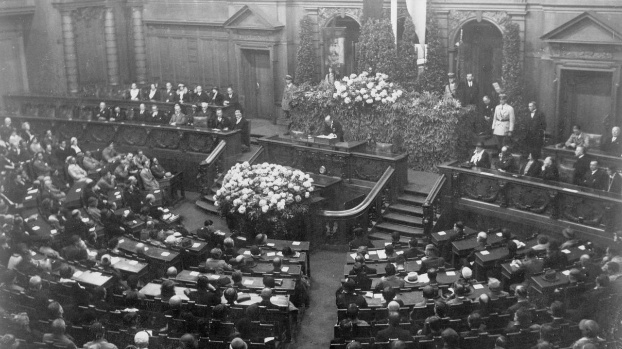 Die Schwarz-weiß-Fotografie von 1922 zeigt den gut besetzten Plenarsaal des Deutschen Reichtstags in Berlin. Die Schwarz-weiß-Fotografie von 1922 zeigt den gut besetzten Plenarsaal des Deutschen Reichtstags in Berlin.