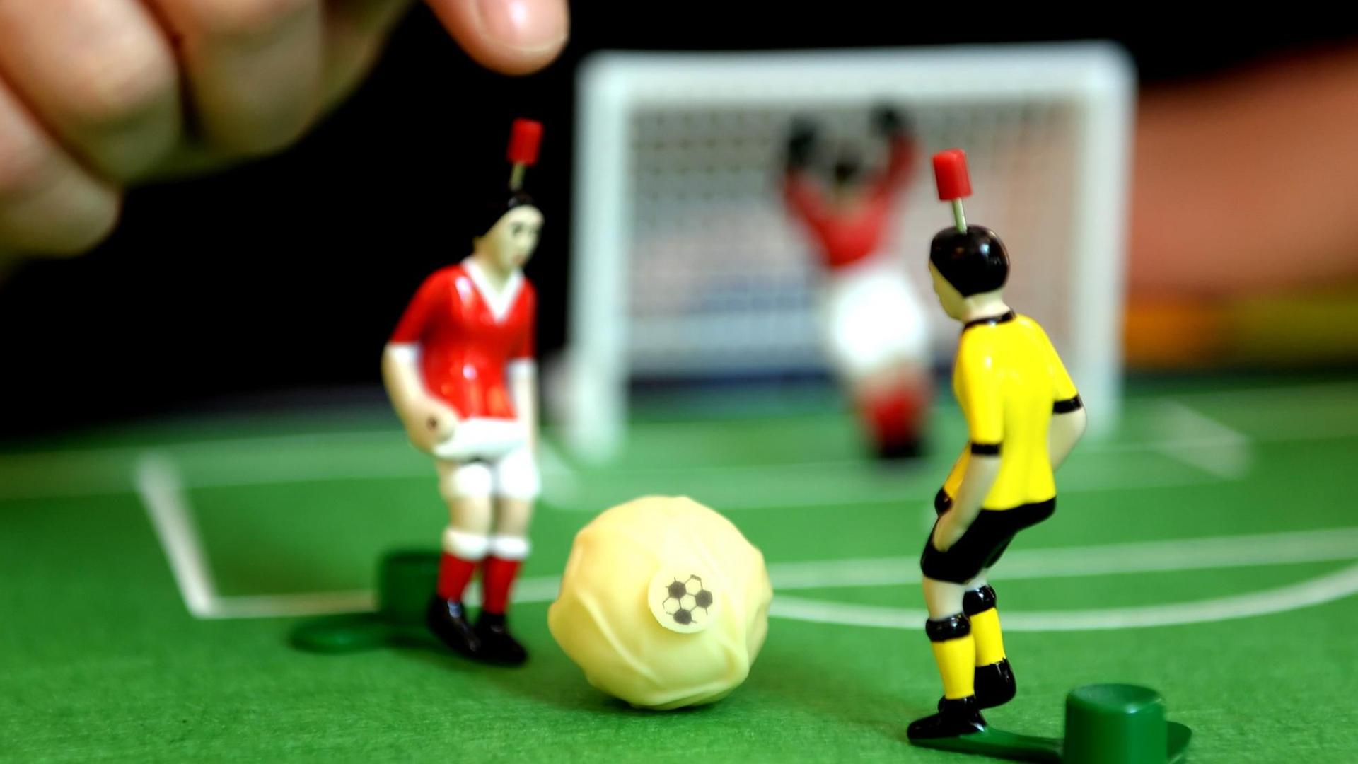 Zwei Tipp-Kick-Figuren auf grünem Spielfeld. Zwei Tipp-Kick-Figuren auf grünem Spielfeld.