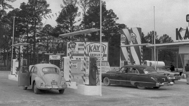 Ein VW Käfer steht an einer Tankstelle in den USA in den 60er-Jahren.