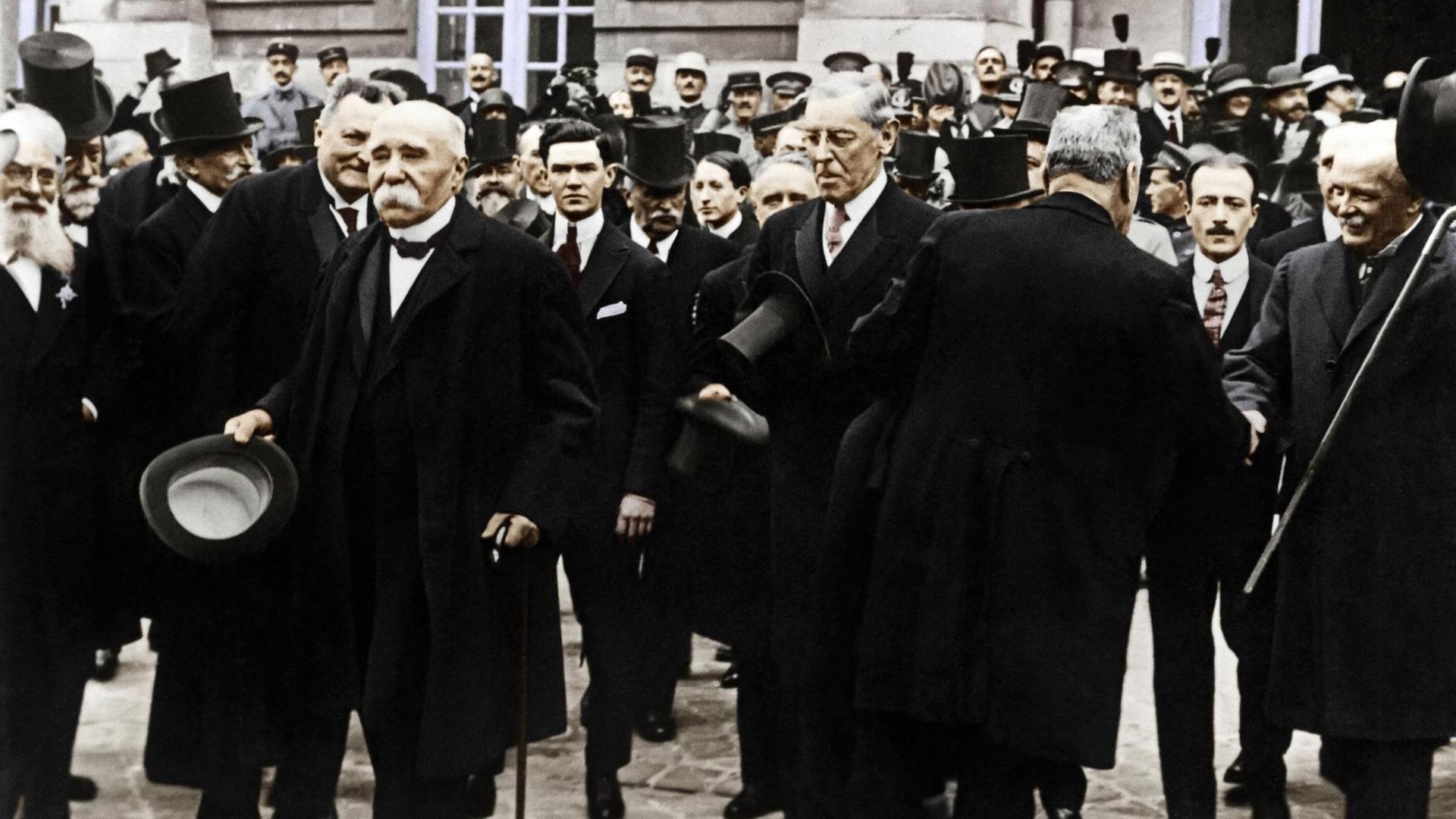 Unterzeichnung des Versailler Friedensvertrages am 28. Juni 1919. Georges Clemenceau und Woodrow Wilson verlassen mit anderen Männern das Schloß von Versailles nach der Vertragsunterzeichnung. Unterzeichnung des Versailler Friedensvertrages am 28. Juni 1919. Georges Clemenceau und Woodrow Wilson verlassen mit anderen Männern das Schloß von Versailles nach der Vertragsunterzeichnung.