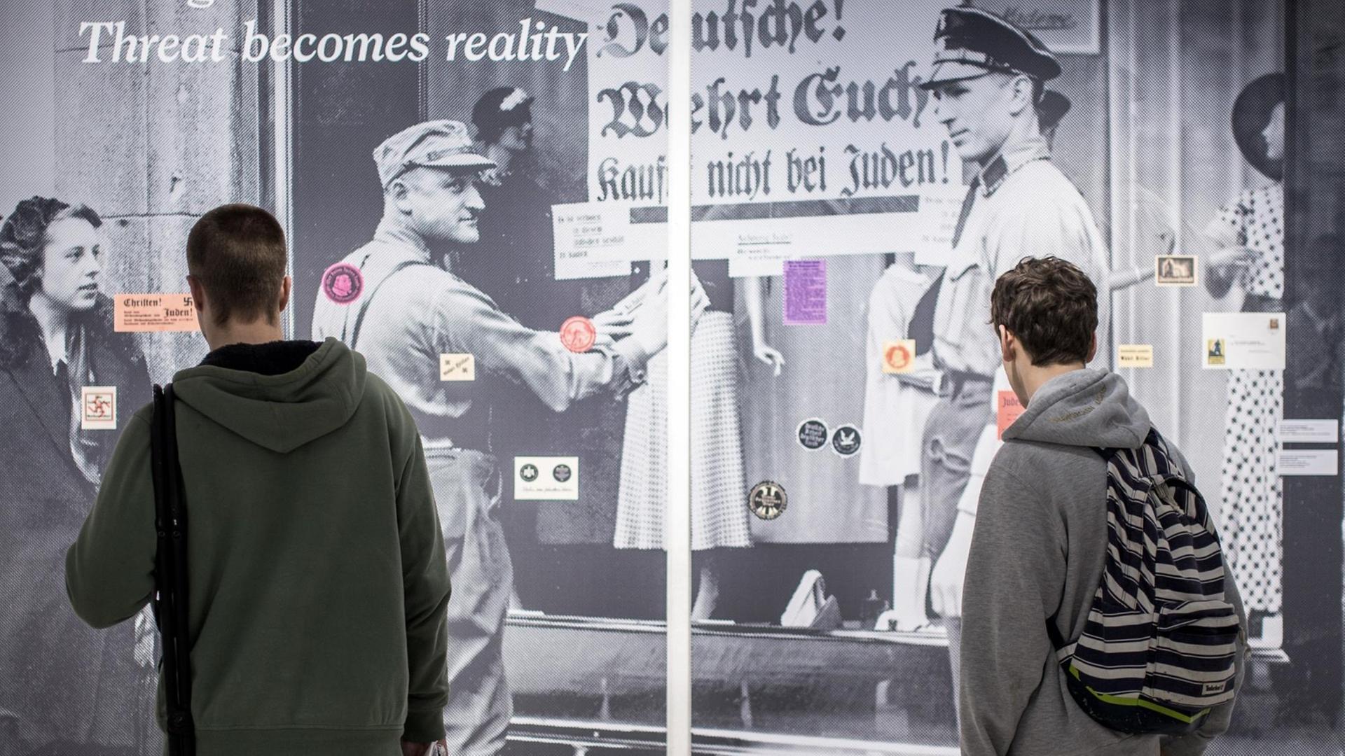 Jugendliche betrachten eine Wand mit verschiedenen antisemitischen Klebezetteln am 2017 im NS-Dokumentationszentrum in München Jugendliche betrachten eine Wand mit verschiedenen antisemitischen Klebezetteln am 2017 im NS-Dokumentationszentrum in München