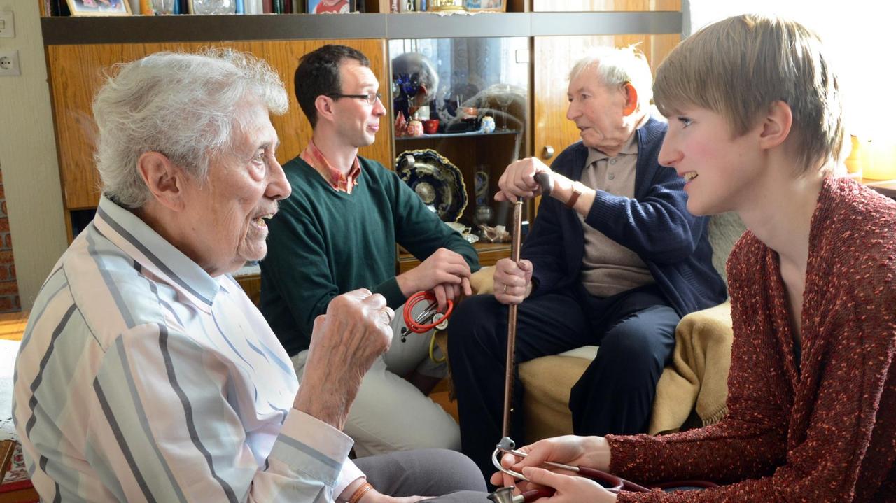 Bei einem Hausbesuch bei der 90-jährigen Anita Pfeiffer und ihrem 93-jähren Ehemann Ernst (2.v.r.) in Wettin bei Halle (Sachsen-Anhalt) kann Medizinstudentin Isabel Hillmann (r) mit Landarzt Dr. Stephan Fuchs (2.v.l.) Patientengespräche führen