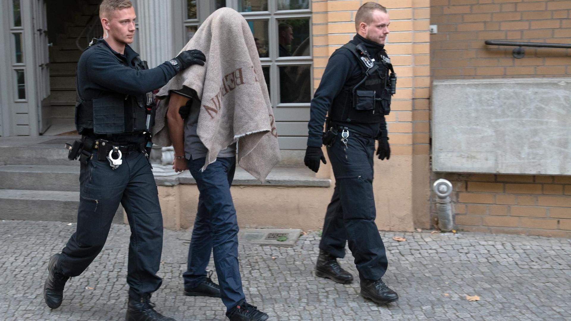 Polizisten in Berlin führen einen verdächtigen Mann nach einer Razzia gegen Mitglieder arabischer Großfamilien ab. Polizisten in Berlin führen einen verdächtigen Mann nach einer Razzia gegen Mitglieder arabischer Großfamilien ab.