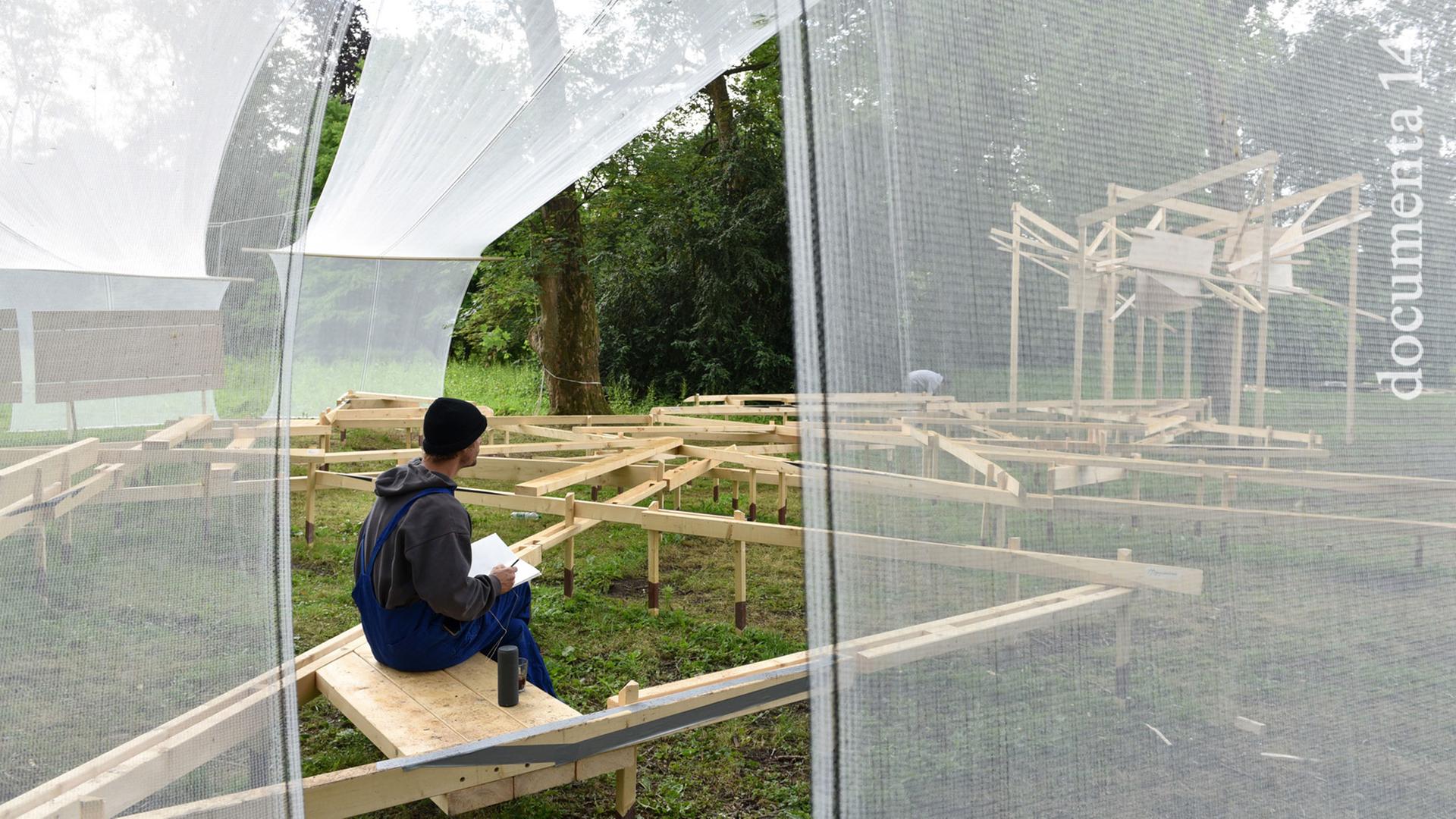 Ein Mann sitzt am 07.06.2017 in der Karlsaue in Kassel in der Ciudad Abierta (Offene Stadt), einem chilenischen Architekturlabor und Kunstwerk auf der documenta 14. Ein Mann sitzt am 07.06.2017 in der Karlsaue in Kassel in der Ciudad Abierta (Offene Stadt), einem chilenischen Architekturlabor und Kunstwerk auf der documenta 14.
