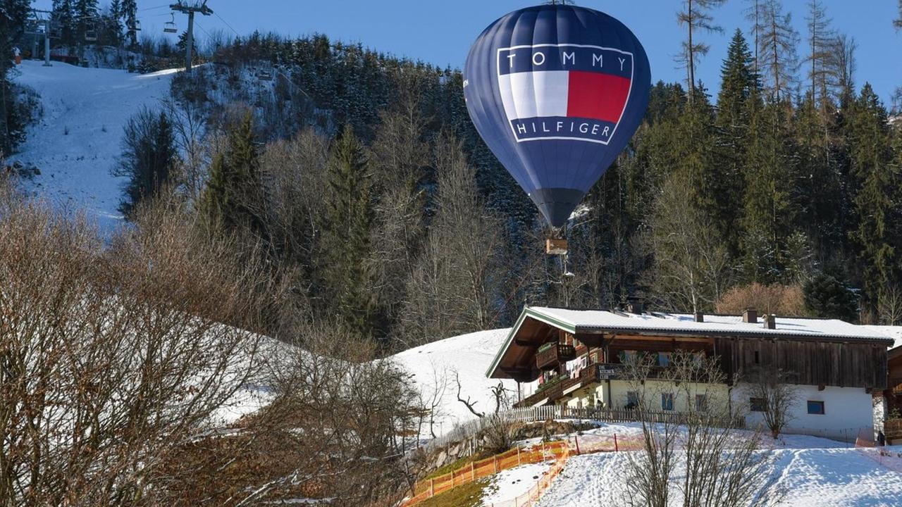 Ein Heißluftballon mit dem Logo der Marke "Tommy Hilfiger" schwebt über dem Hahnenkamm in Kitzbühel. Ein Heißluftballon mit dem Logo der Marke "Tommy Hilfiger" schwebt über dem Hahnenkamm in Kitzbühel.