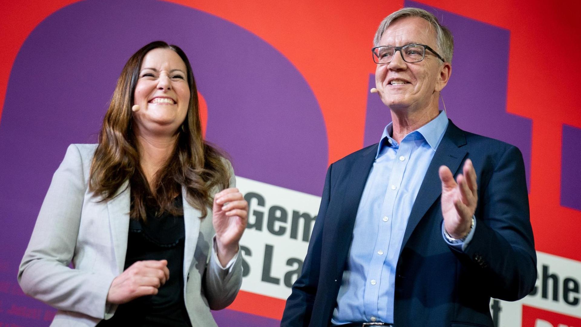 Janine Wissler und Dietmar Bartsch stehen auf einer Bühne. Janine Wissler und Dietmar Bartsch stehen auf einer Bühne.
