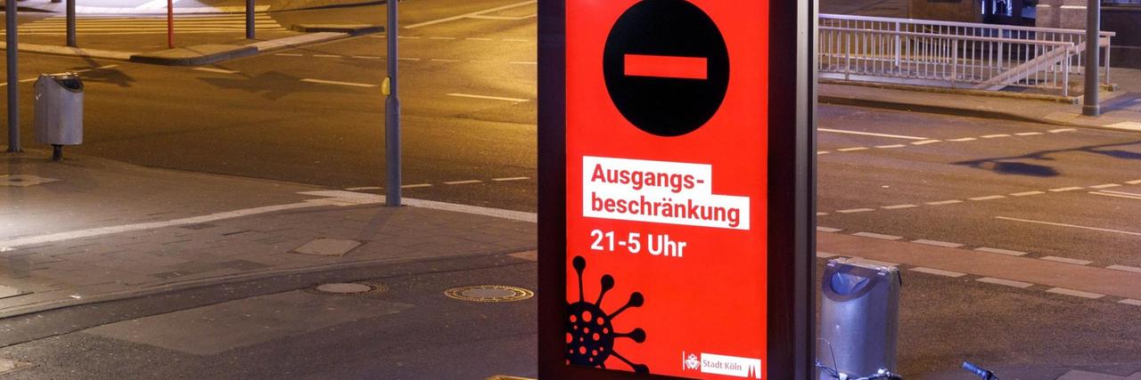 Unter anderem in Köln gelten Ausgangsbeschränkungen, auf die im öffentlichen Raum hingewiesen wird. Unter anderem in Köln gelten Ausgangsbeschränkungen, auf die im öffentlichen Raum hingewiesen wird.