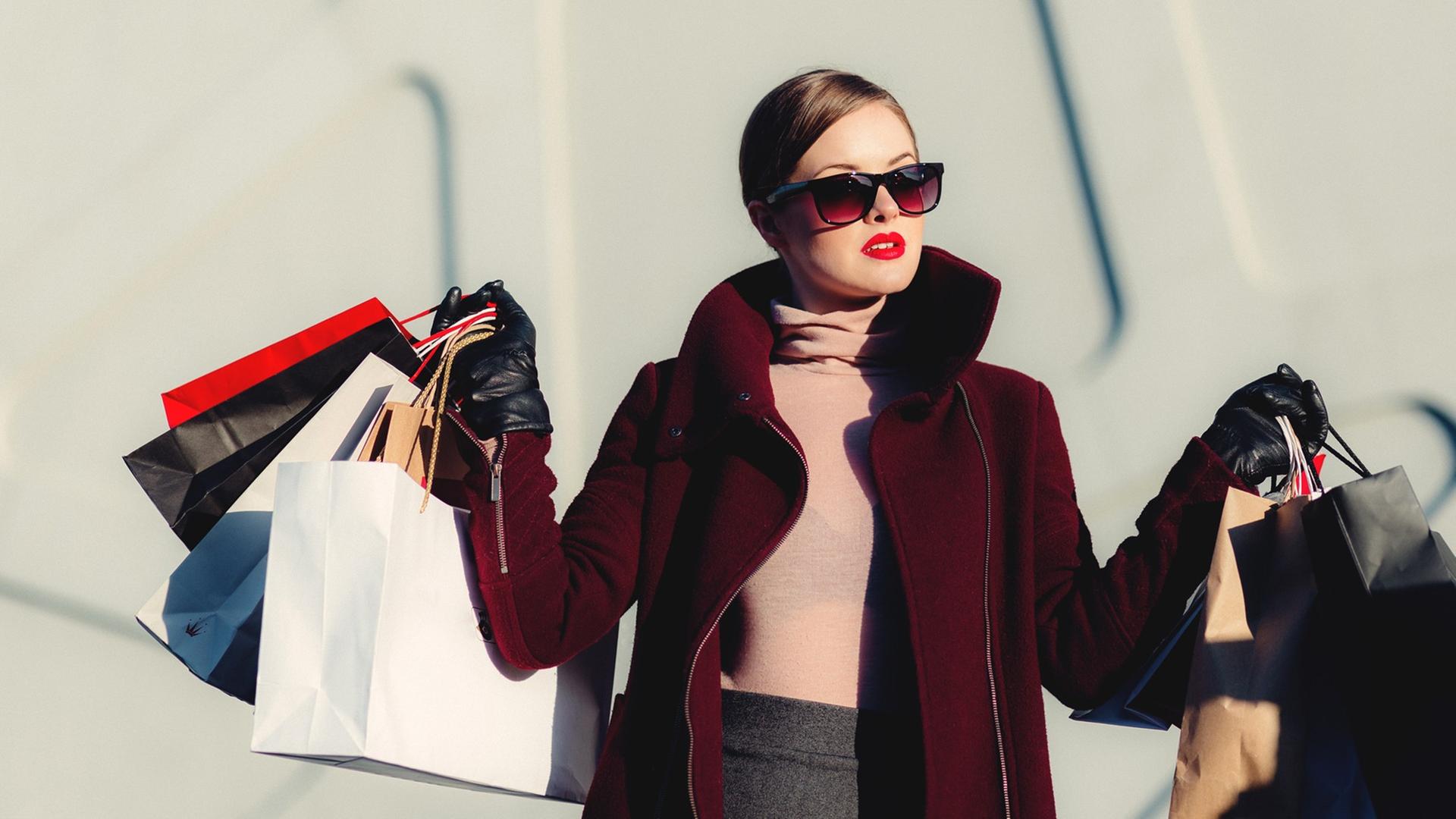 Eine elegante Frau trägt viele Shoppingtüten. Eine elegante Frau trägt viele Shoppingtüten.