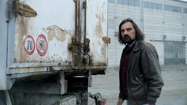 Ein Mann steht an einem Lastwagen: Szene aus dem Film "Teret - Die Fracht" vom serbischen Regisseur Ognjen Glavonić