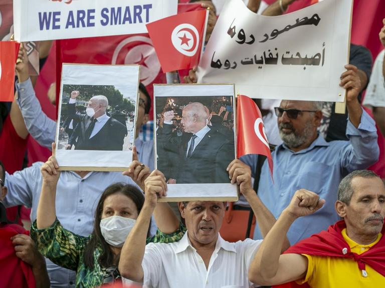 Demonstrierende halten Bilder von Tunesiens Präsident Kais Saied in die Höhe.