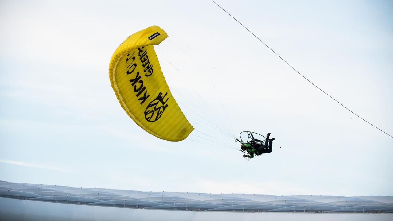 Ein Motorschirmflieger mit der Aufschrift "Kick Out Oil!" muss vor dem Anpfiff in der Münchener Arena notlanden, da seine Gassteuerung ausgefallen ist. 
