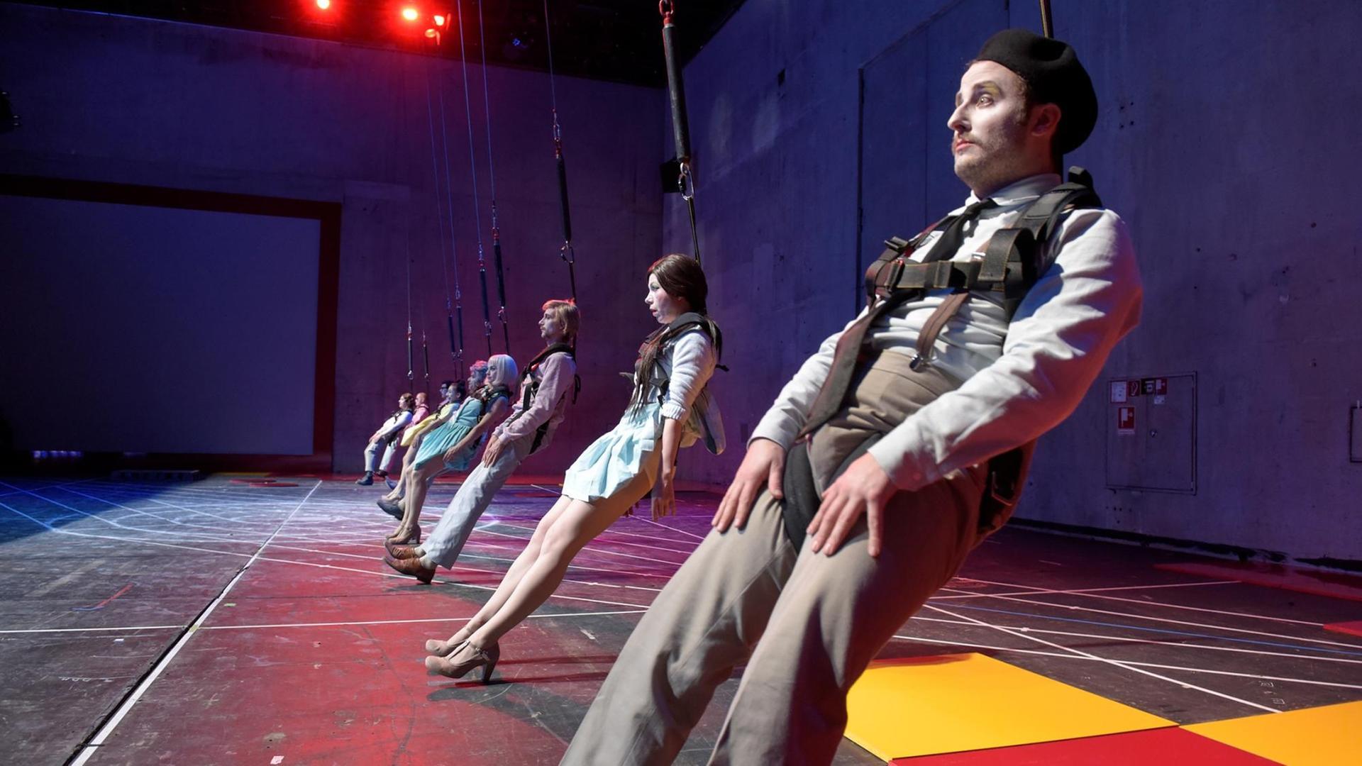 Eine Reihe Schauspieler an Seilen hängend Eine Reihe Schauspieler an Seilen hängend