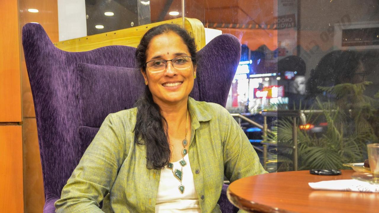 Jayanthi Rajagopal sitzt lächelnd auf einem Sessel. Jayanthi Rajagopal sitzt lächelnd auf einem Sessel.