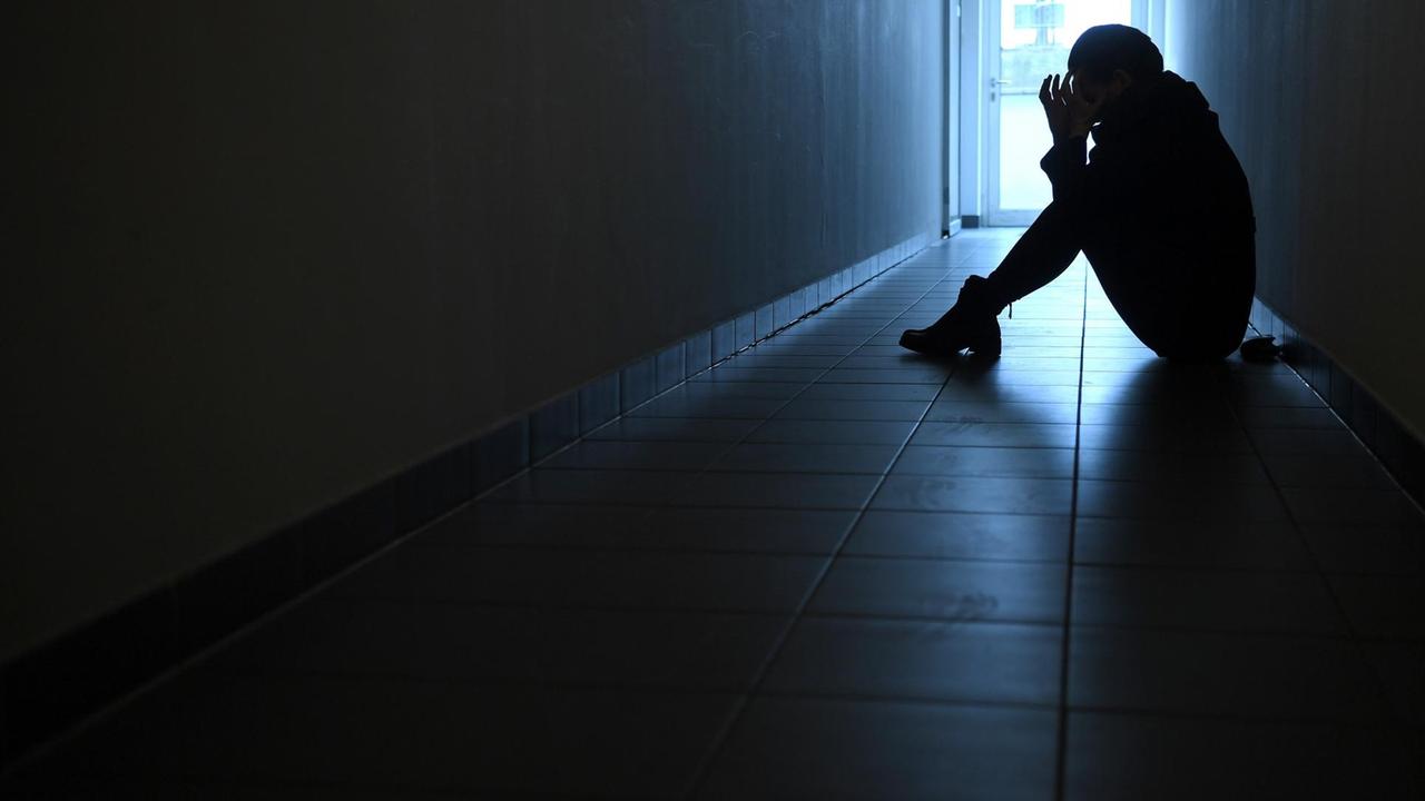 Der Schattenriss einer Frau im Gegenlicht in einem dunklen Gang. Der Schattenriss einer Frau im Gegenlicht in einem dunklen Gang.