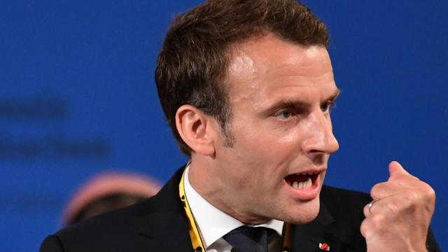 Macron steht mit der Karlspreismedaille am Rednerpult und ballt die Faust. Macron steht mit der Karlspreismedaille am Rednerpult und ballt die Faust.