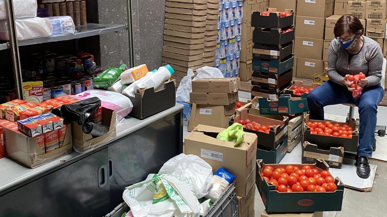 Ein enger Lagerraum vollgestopft mit Lebensmittelkartons unter anderem gefüllt mit vielen Tomaten.