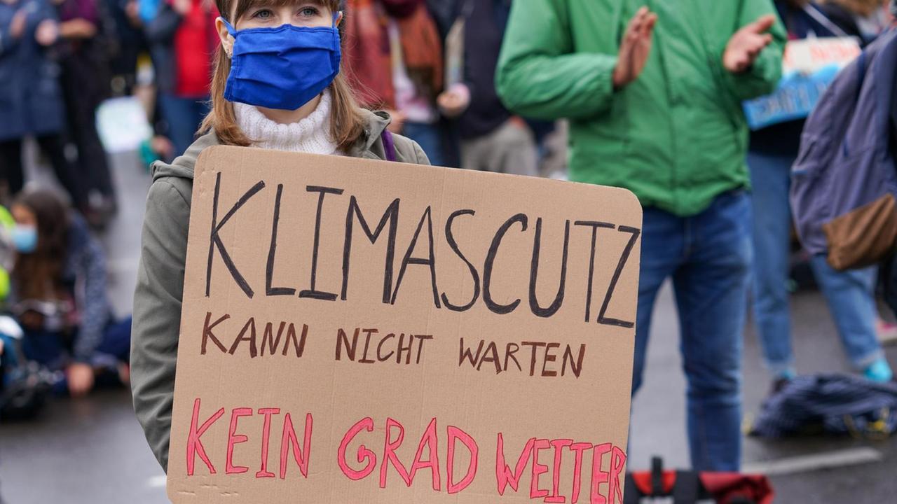 Teilnehmerin einer Fridays-for-Future-Demo in Berlin hält ein Plakat, auf dem "Klimaschutz kann nicht warten - Kein Grad weiter" steht Teilnehmerin einer Fridays-for-Future-Demo in Berlin hält ein Plakat, auf dem "Klimaschutz kann nicht warten - Kein Grad weiter" steht
