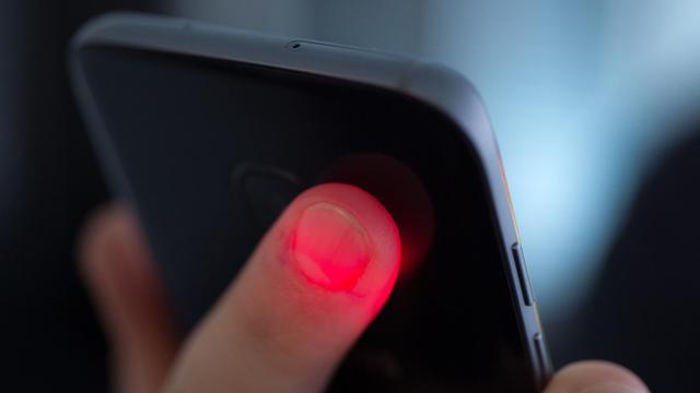 Detailaufnahme: Ein Mann misst seinen Herzschlag mit dem Sensor auf der Rückseite seines Smartphones.