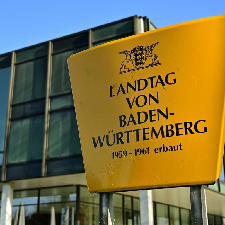 Außenaufnahme des Landtags von Baden-Württemberg. Im Vordergrund ein Schild mit der Aufschrift. Landtag von Baden-Württemberg. 1959-1961 erbaut.