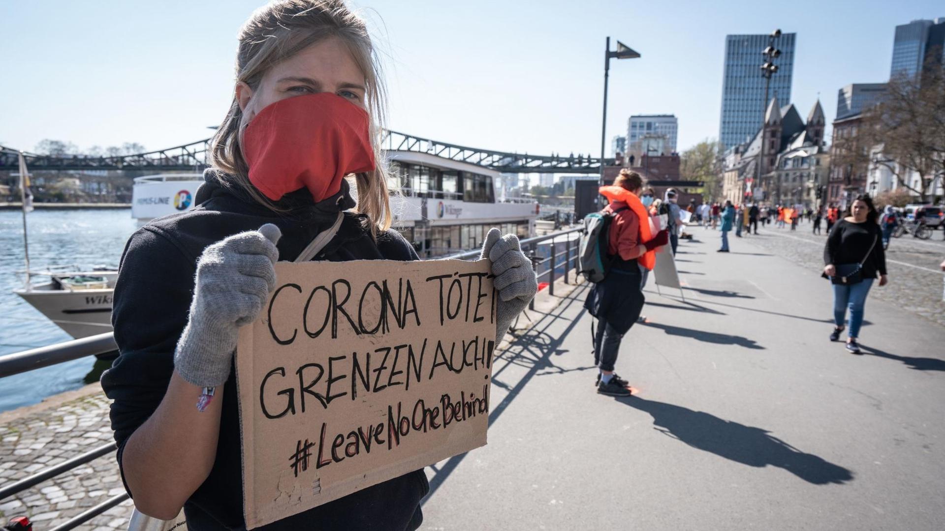 Mehrere Menschen stehen mit Mindestabstand und Schildern für #leavenoonebehind in Frankfurt am Main. Mehrere Menschen stehen mit Mindestabstand und Schildern für #leavenoonebehind in Frankfurt am Main.