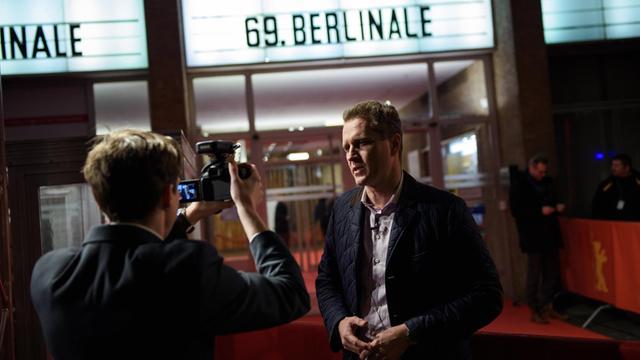 Der AfD-Bundestagsabgeordneter Petr Bystron steht vor dem Kino International im Rahmen der Berlinale-Premiere des Dokumentrafilms "Das Geheimarchiv im Warschauer Ghetto" und spricht in eine Kamera (10.02.2019)