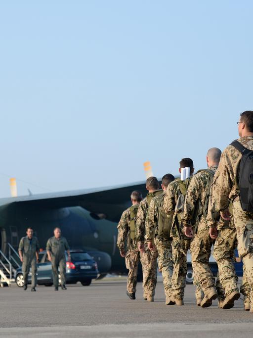 Soldaten gehen auf dem Nato-Flugplatz in Hohn (Schleswig-Holstein) auf eine Transall Transportmaschine zu.