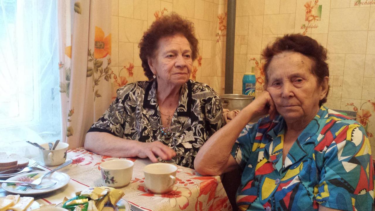 Zwei ältere Frauen am Küchentisch.