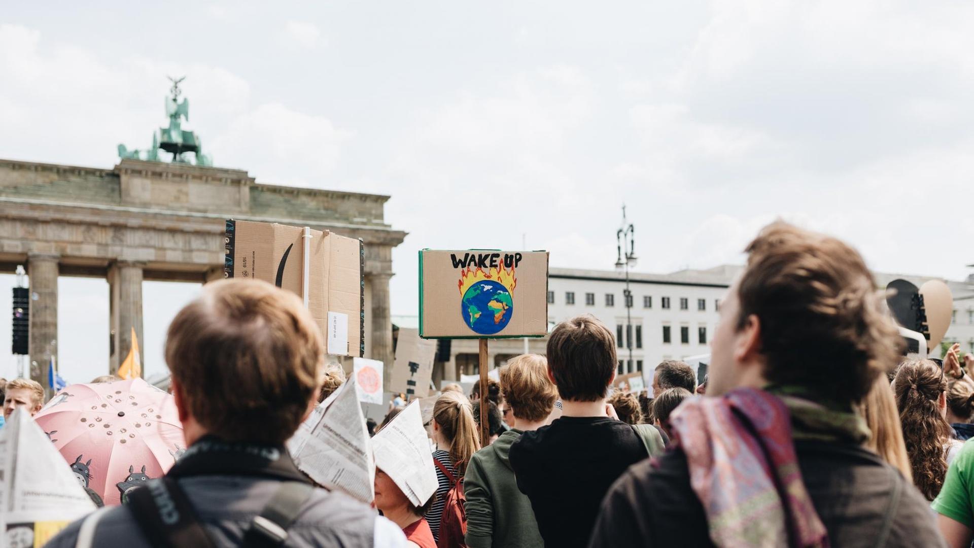 Junge Menschen protestieren am Brandenburger Tor in Berlin gegen die Erderwärmung, auf einem Schild steht "Wake up / Wacht auf". Junge Menschen protestieren am Brandenburger Tor in Berlin gegen die Erderwärmung, auf einem Schild steht "Wake up / Wacht auf".