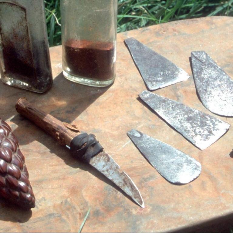 Messer, Klingen und Amulette liegen auf einem Tisch.