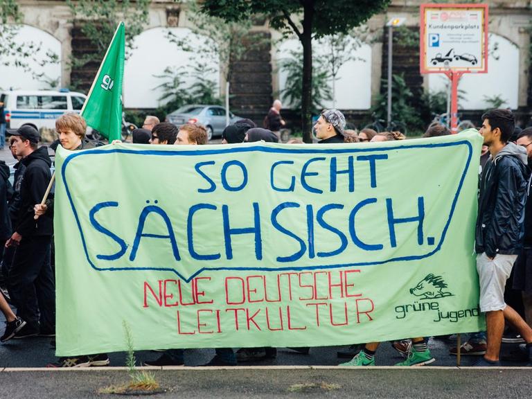 Asylbefürworter ziehen am 27.07.2015 in Dresden (Sachsen) mit einem Banner "So geht sächsisch - neue deutsche Leitkultur" durch die Innenstadt von Dresden.