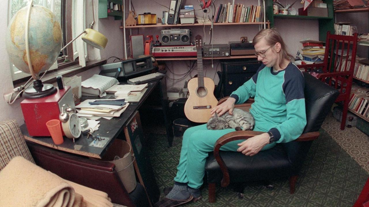 Baggerführer und Liedermacher Gerhard Gundermann sitzt in seinem Wohnzimmer