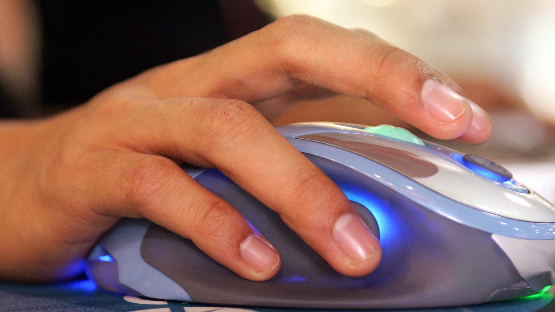 Eine Hand bedient eine Computermaus. Eine Hand bedient eine Computermaus.